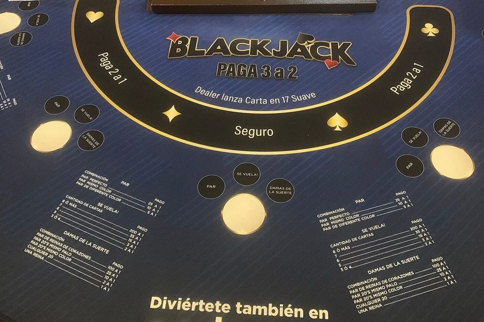 A blackjack table with cards dealt and chips placed in the betting boxes