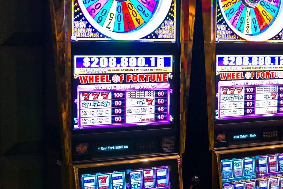 Two video slot machines with bonus-wheel toppers and lit jackpot displays