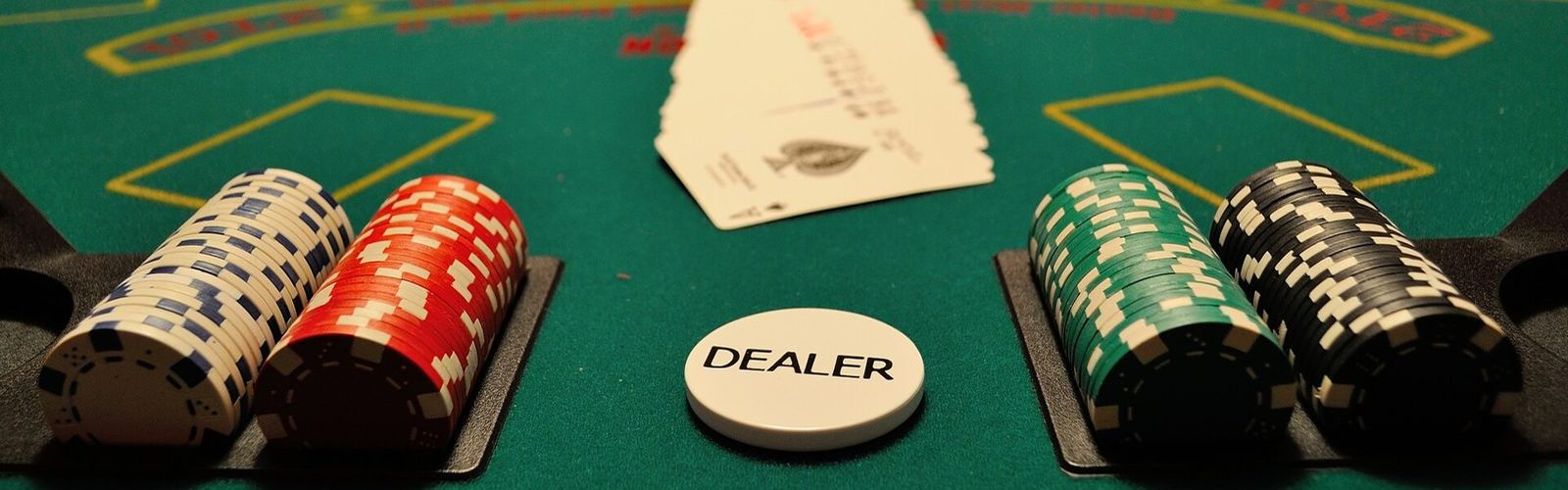 Dealer's chip trays and cash on a green casino table