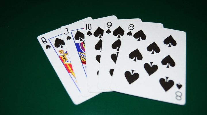 Straight flush in spades on a green poker table